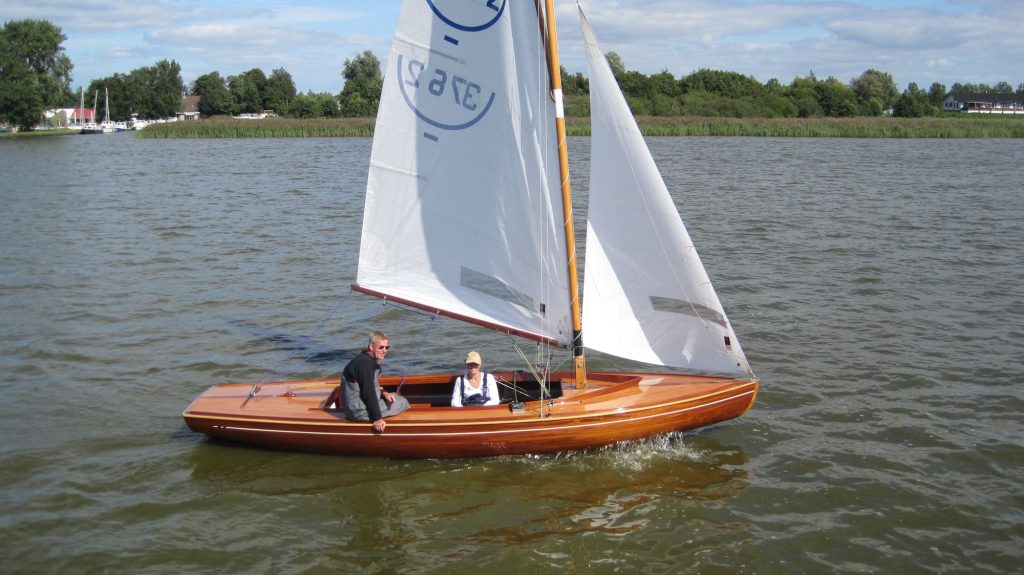 Houten zeilboot met twee opvarenden