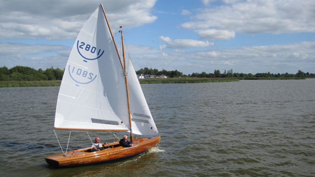 Houten zeilboot onder wolkenlucht
