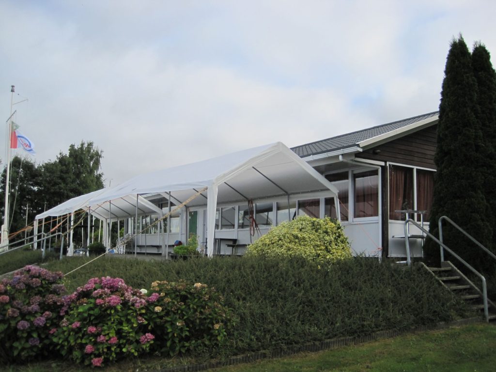 Clubhuis met witte partytenten en hortensia's