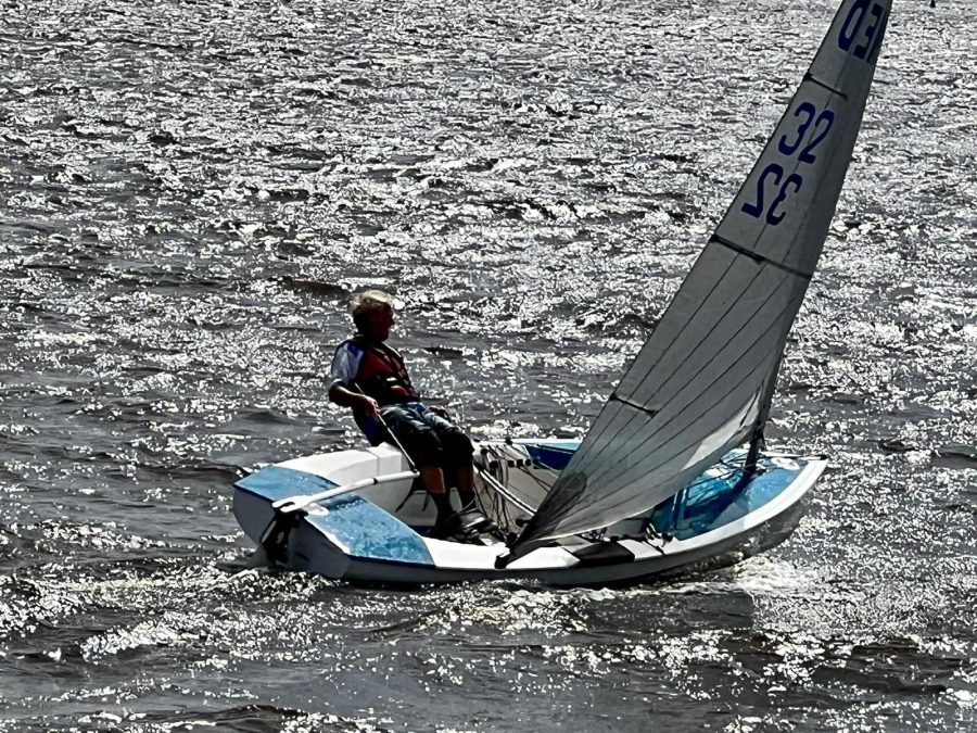 Zeiler hangt buitenboord in een eenmansboot