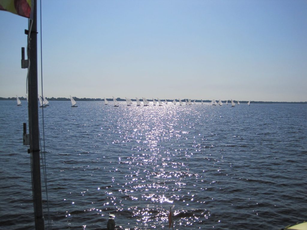 Glinsterend water met in de verte veel zeilboten