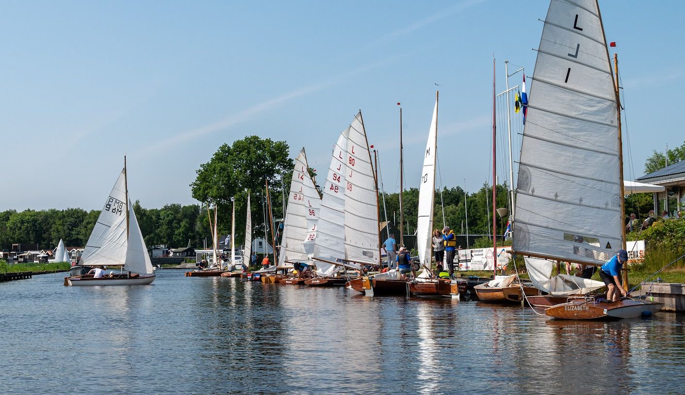 Houten zeilboten liggen aan een steiger