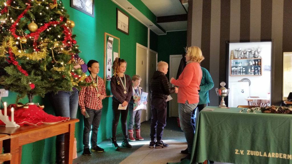 Groep kinderen met medailles in het clubhuis