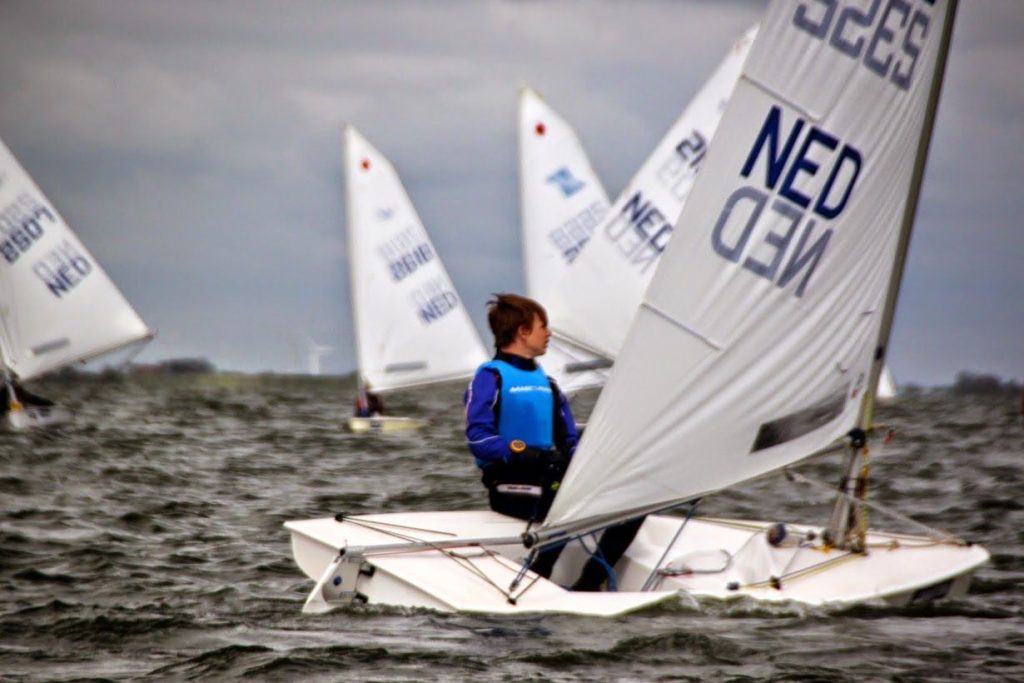 Jonge zeiler in een kleine zeilboot