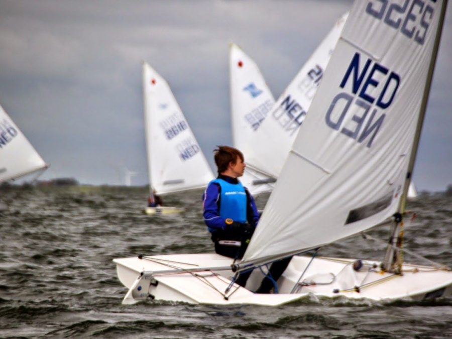 Jonge zeiler in een kleine zeilboot