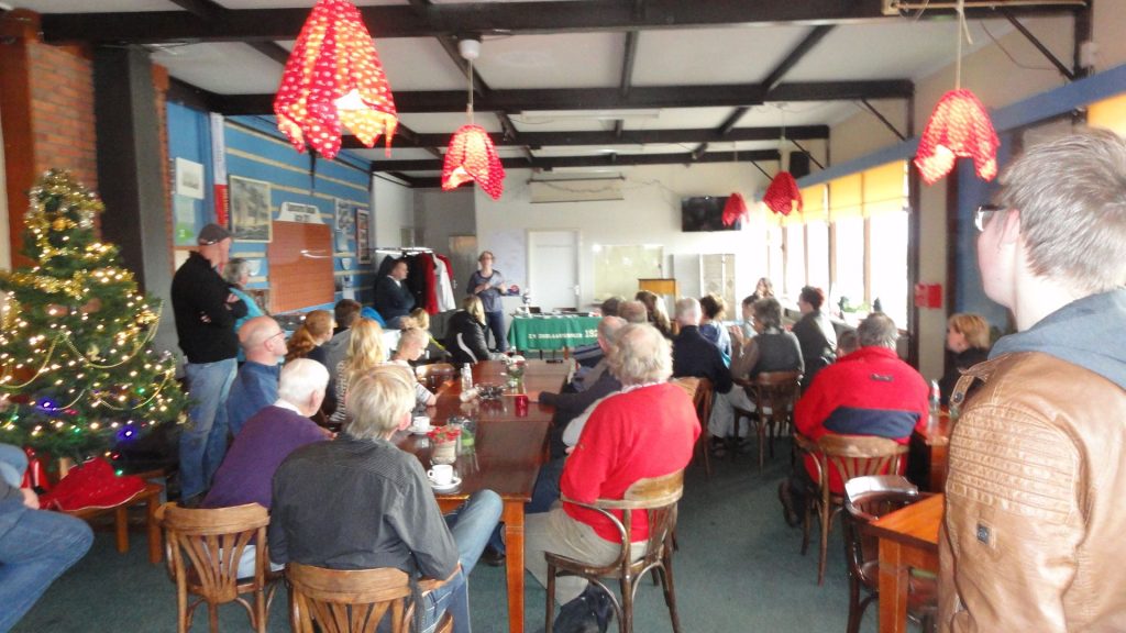 Mensen aan tafel in het versierde clubhuis