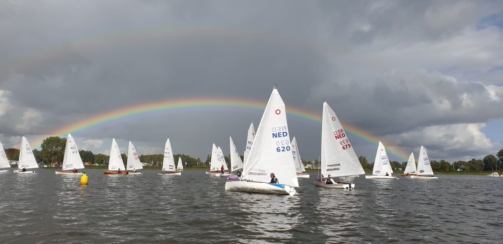 Zeilboten op het meer met een regenboog in de lucht