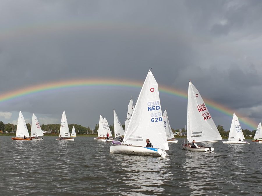 Zeilboten op het meer met een regenboog in de lucht
