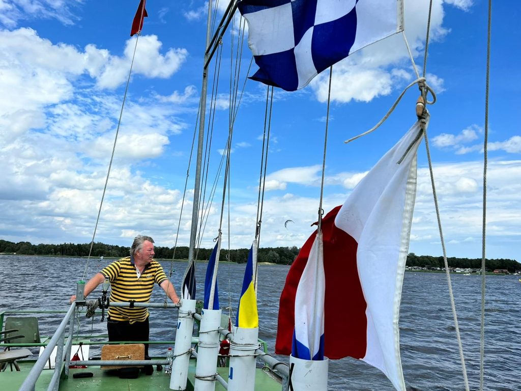 Vrijwilliger bij seinvlaggen onder blauwe lucht