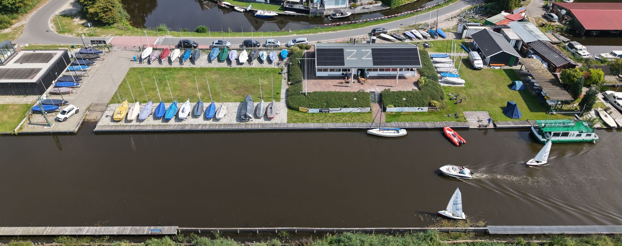 Luchtfoto van het clubhuis, gestalde boten en het water