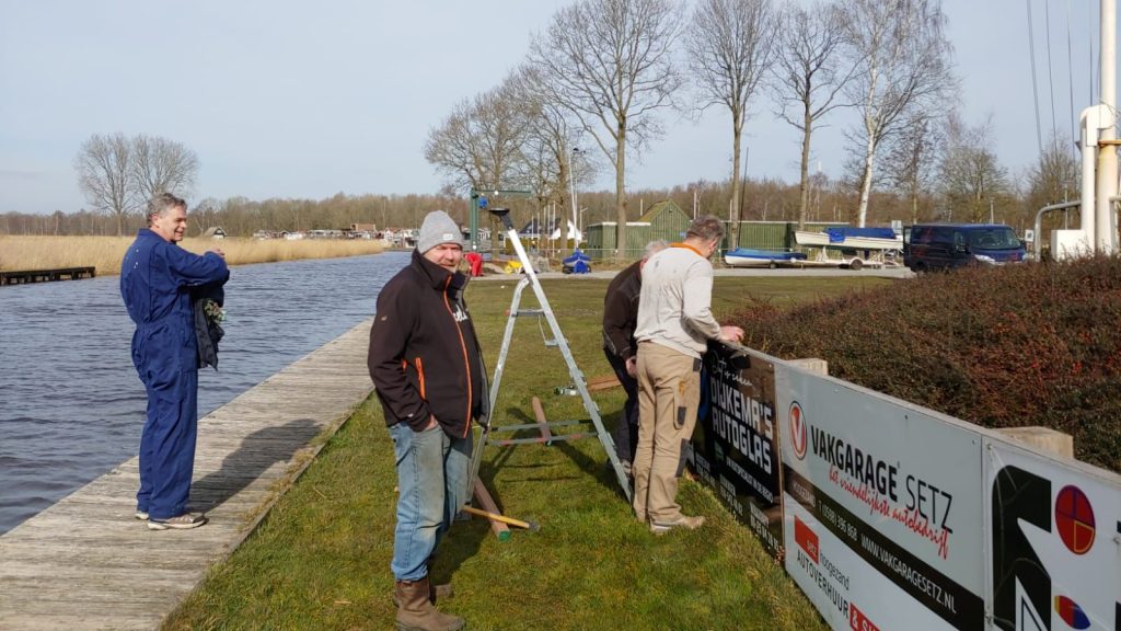 Vrijwilligers werken op het terrein langs het water